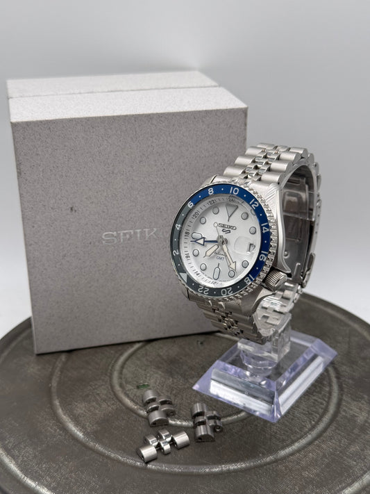 Seiko 5 Sports GMT Automatic Watch – White Dial, Blue & Black Bezel, Stainless Steel Jubilee Bracelet, with Box