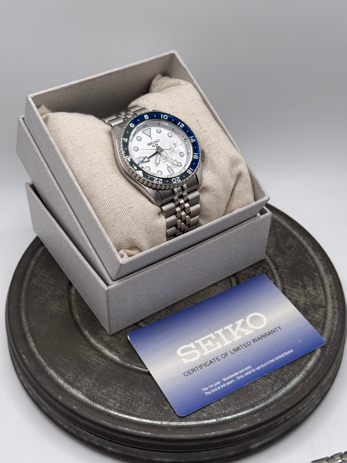 Seiko 5 Sports GMT Automatic Watch – White Dial, Blue & Black Bezel, Stainless Steel Jubilee Bracelet, with Box