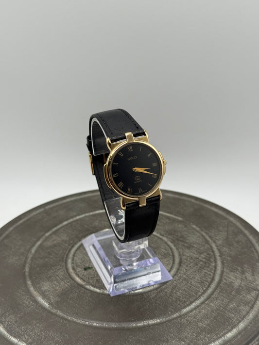 Vintage Gucci Swiss Made Quartz Watch – Black Dial, Gold Tone Case, Roman Numerals, Black Leather Original buckle